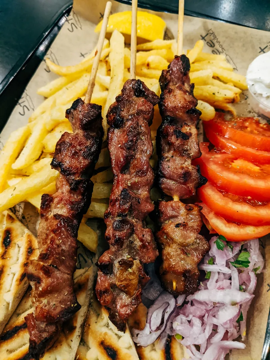 Grillade souvlaki-spett med pommes, tomat och lök