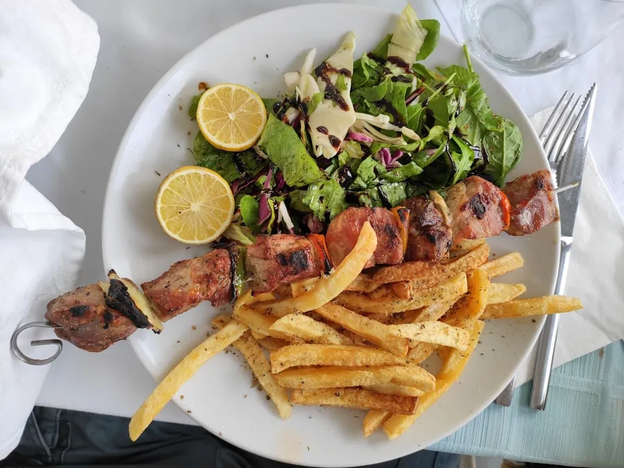 Grillspett serverat med greksallad och pommes